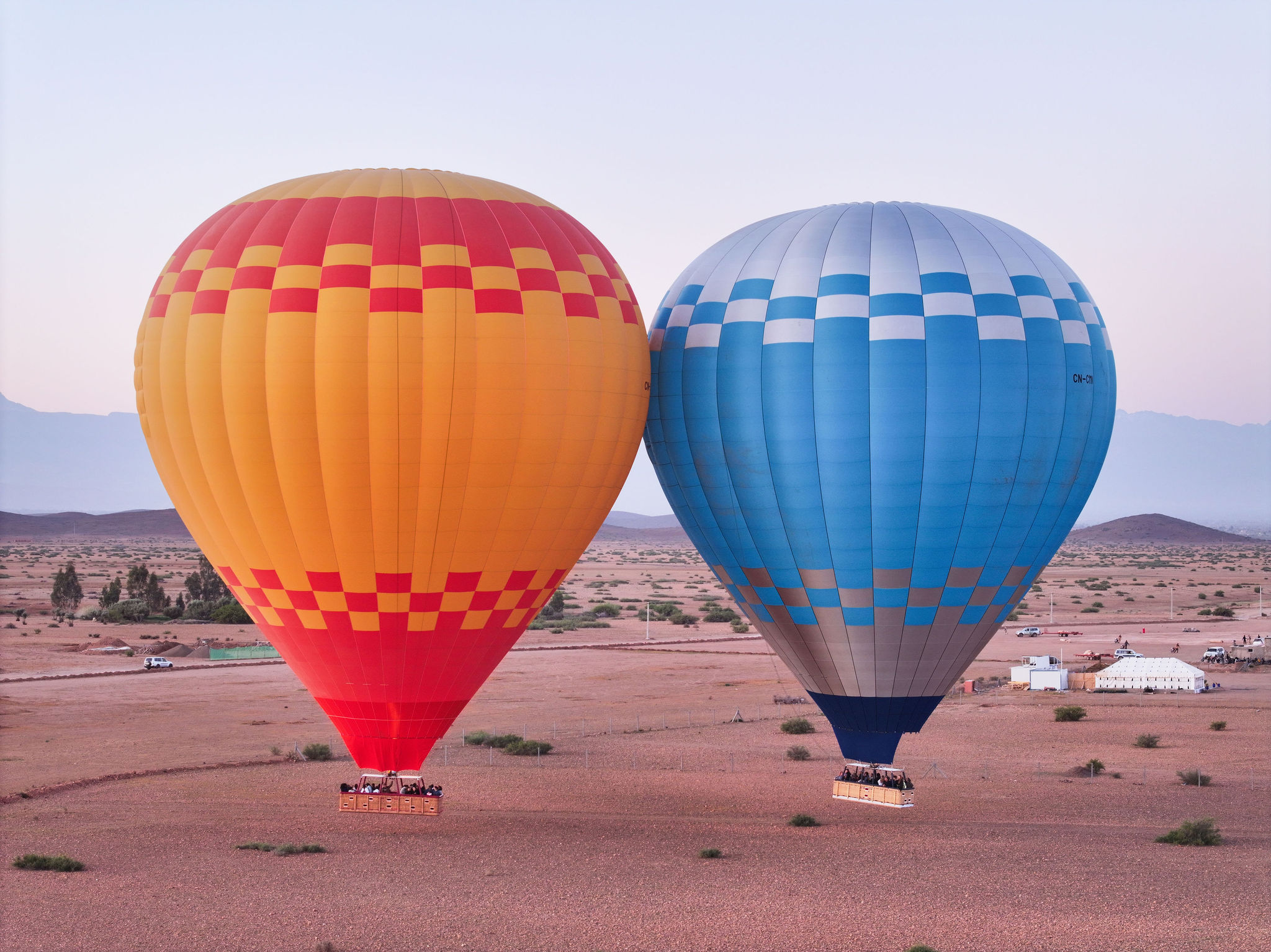 Two hot air balloons rising at dawn over the plains near Marrakech